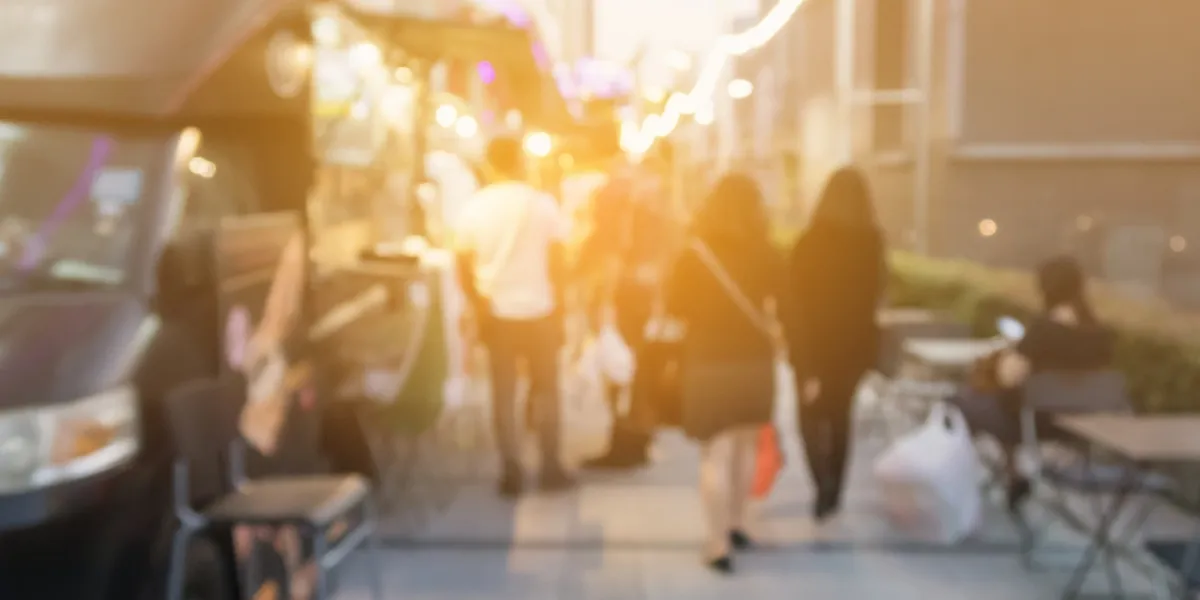 Blurred street scene with people and lights.